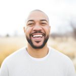 Man in white shirt smiling outside