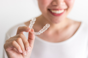 Close up of woman holding Invisalign aligner