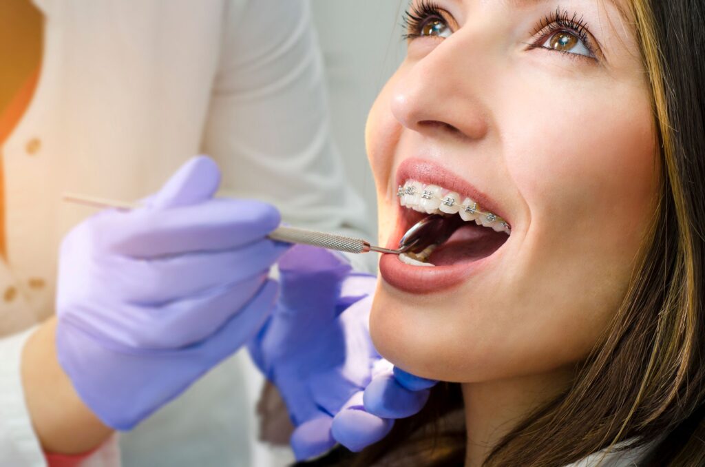 Woman with brown eyes having teeth with braces examined